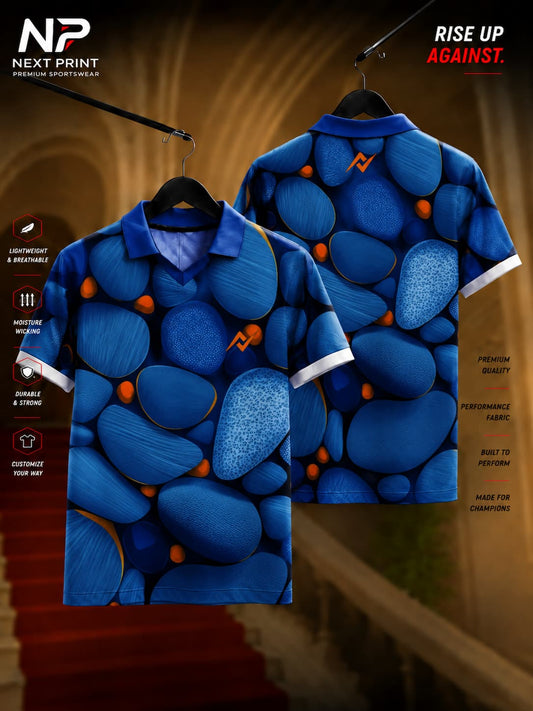 Next Print royal blue custom polo collar sports jersey featuring an abstract pebble-inspired graphic pattern with front and back views.